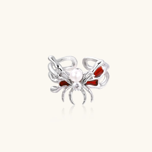White gold plated spider ring with pearl body, clear zirconia center, and red enamel leg accents on adjustable band