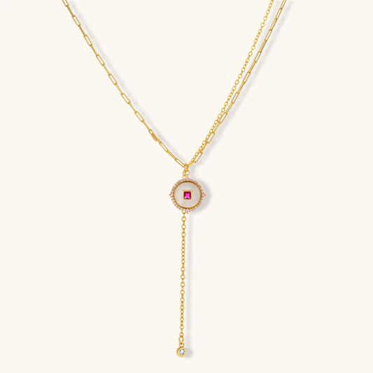 Gold-plated circular medallion necklace set with white enamel base and pink cubic zirconia accent stones