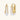 Sculptural gold-plated hoop earrings with flowing curved design and lever-back closure on cream background.