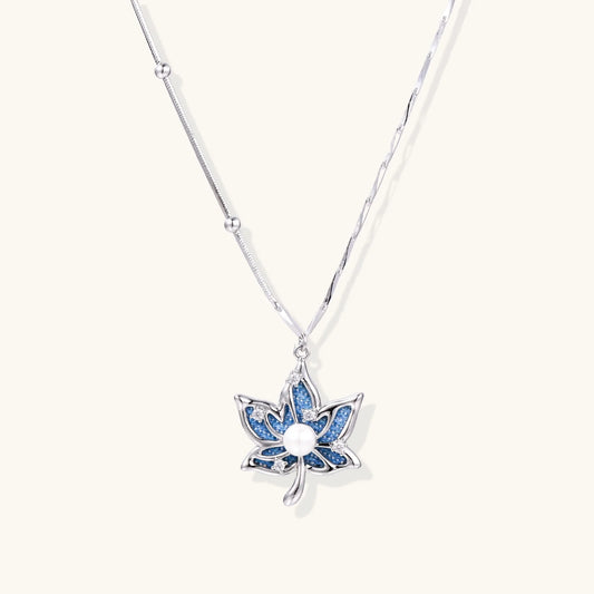White gold-plated lotus pendant with blue denim fabric inlay and sparkling zirconia stones on adjustable chain