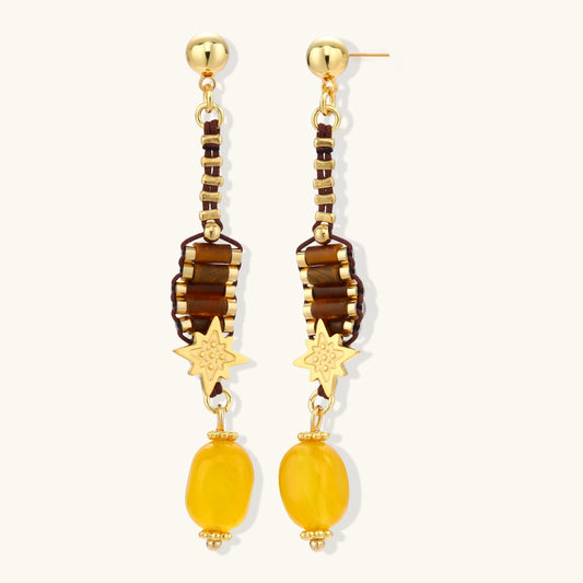 Gold-plated dangle earrings with brown gemstones, star charms, and yellow amber drops on cream background.