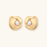Organic-shaped eco-zinc alloy stud earrings with resin pearl centers and sterling silver posts on white background.