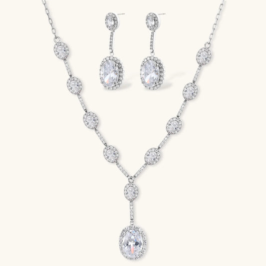 Elegant white gold plated jewelry set with oval cubic zirconia stones in halo settings, featuring Y-necklace and drop earrings.