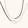 Double-strand necklace with black faceted quartz and white pearls featuring an oversized baroque pearl centerpiece
