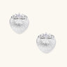 White gold-plated shell-textured stud earrings with three zirconia crystals on ridged surface against cream background.