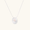 Sterling silver disc necklace with textured finish and centered freshwater pearl on delicate chain
