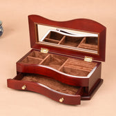 Wooden jewelry box with mirror lid on a beige background